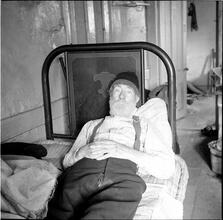Bearded Man Resting on Unmade Bed