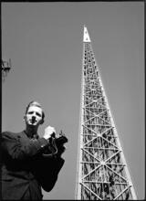 [Richard Wurts standing next to the frame of the Trylon, New York World's Fair site.]