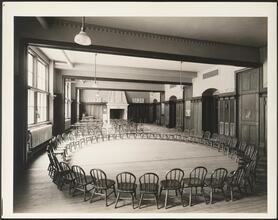 [Interior, room with a circle of chairs.]