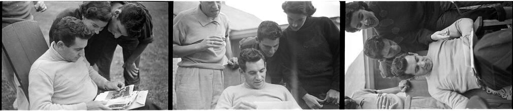 Leonard Bernstein [Leonard Bernstein looking at photographs as people look over his shoulder.]