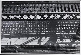 [Trucking away salvaged sections of steel rail.]