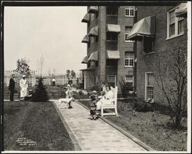 Apartment exterior. People relaxing in garden