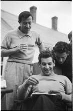 Leonard Bernstein [Men looking over Leonard Bernstein's shoulder at a photograph.]