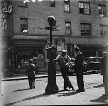 Men Lounging Near Lamp Pole