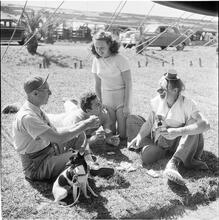 Circus [Group of people playing cards, one is dressed as a clown.]