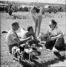 Circus [Group of people playing cards, one is dressed like a clown.]