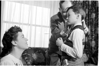 Deaf Children [Two teachers helping a child with his hearing aid.]