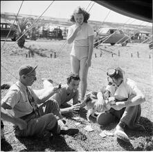 Circus [Group of people playing cards, one is dressed like a clown.]
