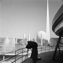 [Photographer taking picture of the New York World's Fair site, with the Trylon and Perisphere visible in the background.]