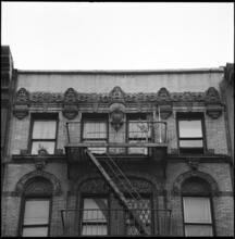[Carved faces on the façade of a building on the north side of St. Mark's Place between Third and Second Avenues.]