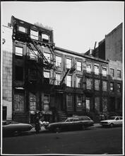 [Boarded up row houses on the north side of East 7th Street, near the corner of Avenue C.]