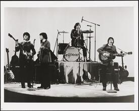 ["Beatlemania" theater still.]