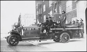 [Fire fighters on early fire engine.]