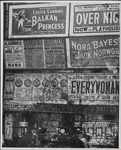 [Theater advertisements posted over storefronts]