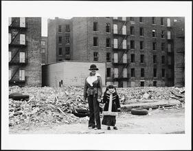 Mother and daughter pause in the ruins, which is still their home, Claremont Parkway.
