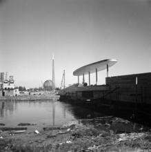 [Construction of the New York World's Fair site, with the frames of the Trylon and Perisphere in the background.]