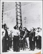 [Fire fighters train with a ladder.]