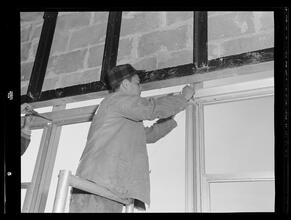 750 3rd Avenue Between 46th and 47th Street. [Construction view], Screwing Gutters Into Place from Inside