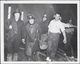 [Firemen carrying body bag.]