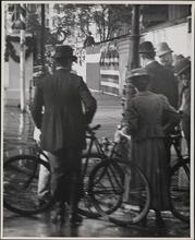 [Bicyclists standing with policeman, Dewey Celebration]
