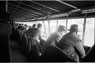Football Writers [Reporters commentating on a football game in a stadium from the press box.]