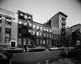 [Boarded up row houses on the north side of East 7th Street, near the corner of Avenue C.]