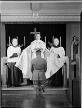 [Man kneeling before priest.]