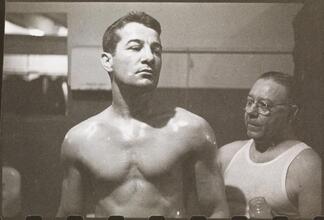 Rocky Graziano, He's a Good Boy Now [Man applying petroleum jelly to Rocky Graziano.]