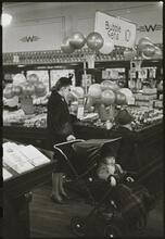 The 5 and 10 [Woman shopping and a child in a stroller at Woolworth's.]