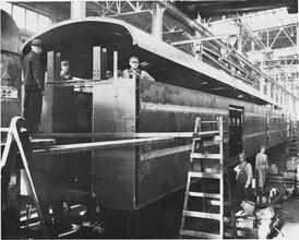 [Men assembling a railroad car.]
