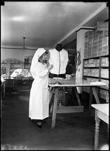 Volunteer for the Stage Women's War Relief signing a vest.