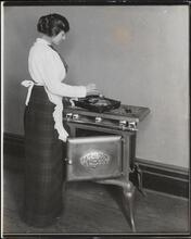 [Gas range with woman cooking.]