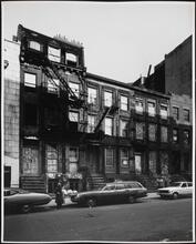 [Boarded up row houses on the north side of East 7th Street, near the corner of Avenue C.]