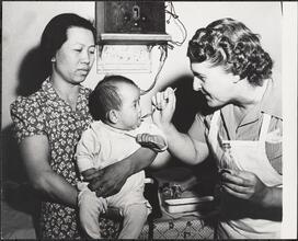 Henry Street Visiting Nurse Service, Helping a Chinese Mother Spoon Feed Medicine to Her Infant.