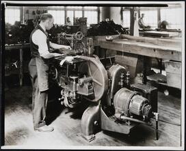 Interior, shoe factory with man at machine