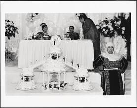[Groom's mother guarding the wedding cakes at a Palestinian wedding at Widdi's Catering Hall.]