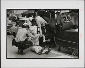 Mounted police officers revive a man found unconscious in the street.; Police Work