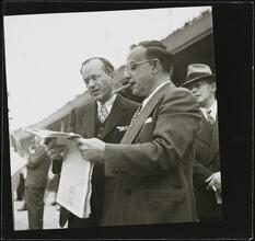 Aqueduct Race Track [Two men reading a newspaper at a racetrack.]