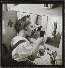 Orphanage [Girl playing with a dollhouse.]