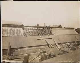[Workers doing construction on roof of Washington Market.]