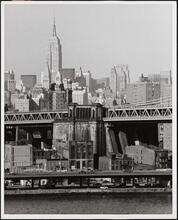 [Looking northeast over the East River beyond the approach to the Manhattan Bridge to the Empire State Building.]