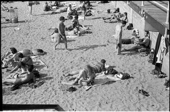 [People relaxing on Coney Island beach.]