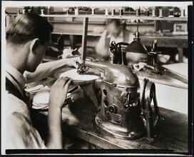 Interior, shoe factory with man at machine