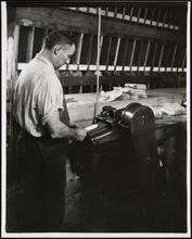 Interior, shoe factory with man at machine