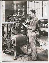 Interior, shoe factory with man at machine