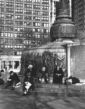 Untitled [Men sitting at and sleeping at base of flagstaff, Union Square]
