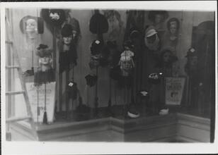 [Women's hats displayed in store window.]