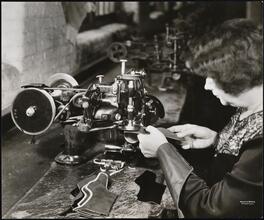 Interior, shoe factory with woman at machine