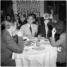 Champagne Cholly Book Party [Group of people talking at a table.]