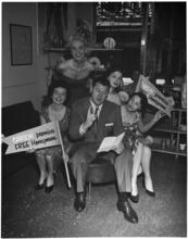 [Jack Carson with other performers at an autograph session.]